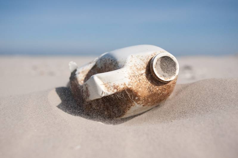 Lege plastic fles op strand